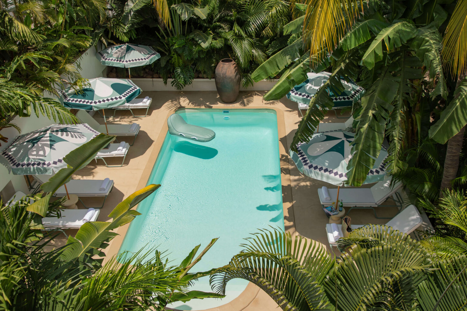 A serene pool in a tropical setting, with lagoon-hued water, designed for privacy